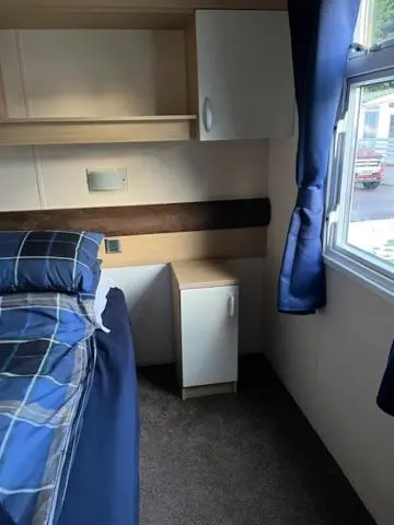 a small bedroom with a bed and a window at Braemar in Dornoch