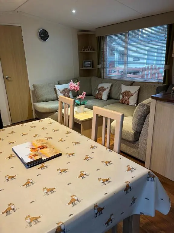 a living room with a table and a couch at Braemar in Dornoch