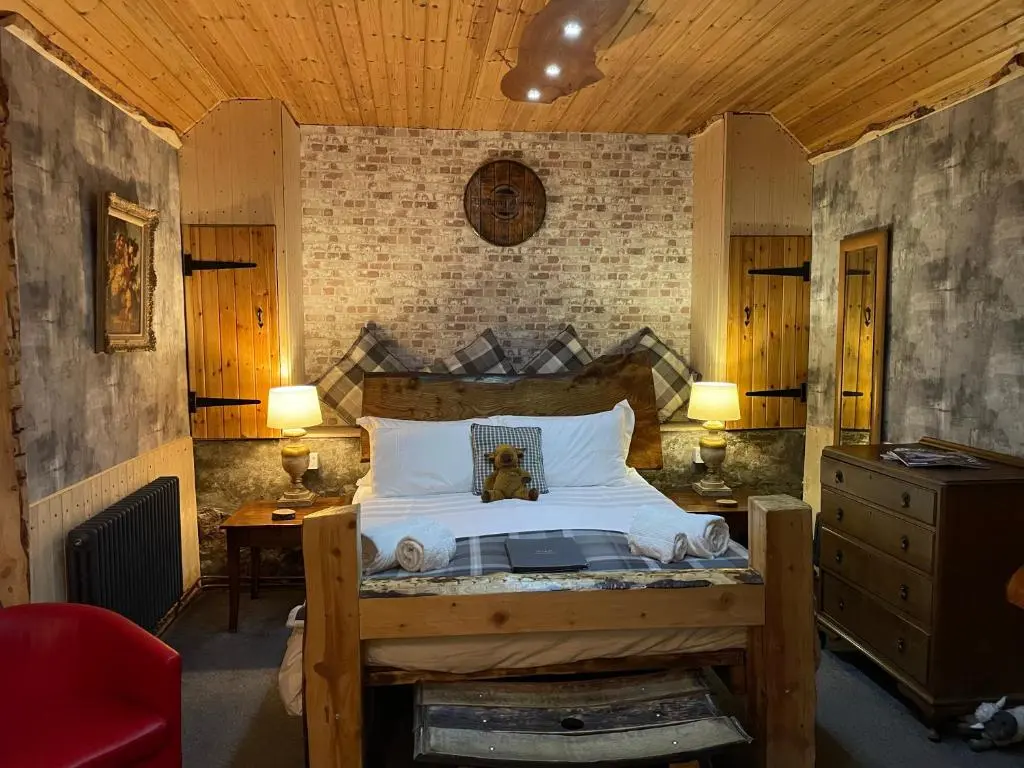 a bedroom with a bed and two tables and two lamps at The Barn | Aberlour in Aberlour