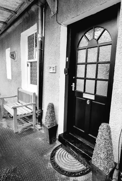 a door of a house with a bench next to it at Inverness City Centre Flat in Inverness