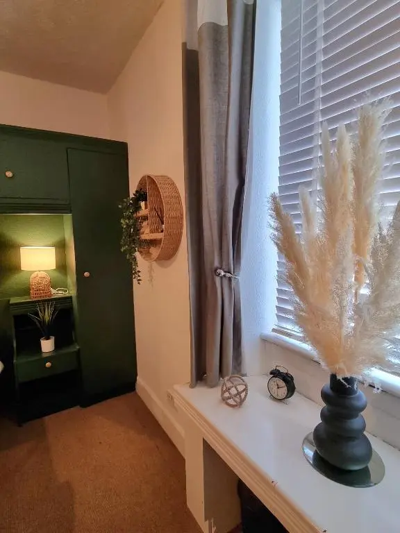 a room with a window and a table with a fan at Inverness City Centre Flat in Inverness