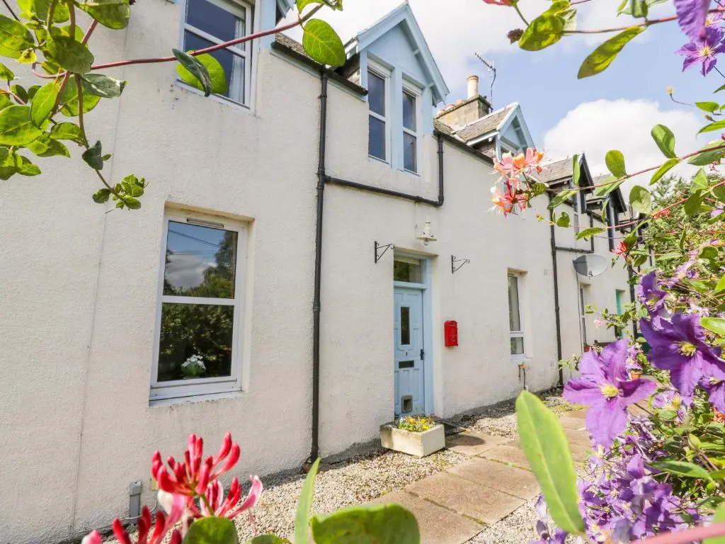 a cottage with flowers in front of it at Church View in Kingussie