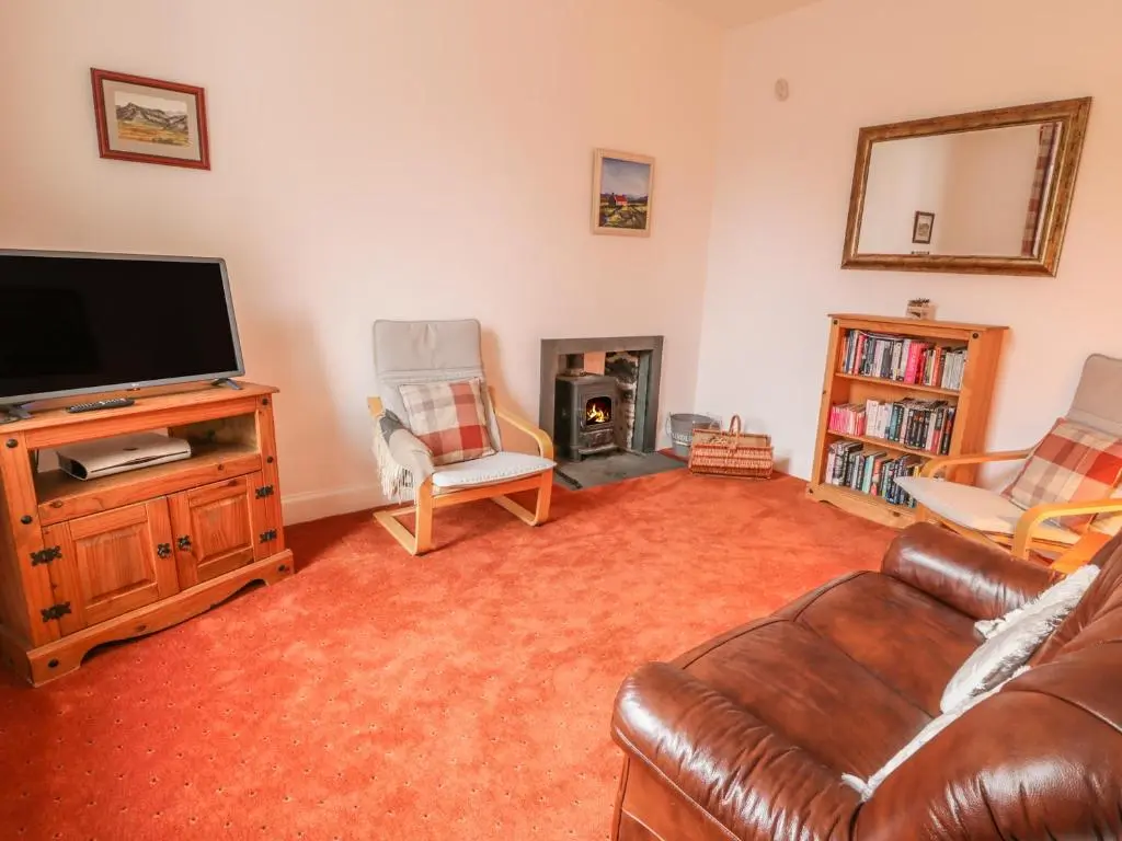 a living room with a couch and a television at Church View in Kingussie