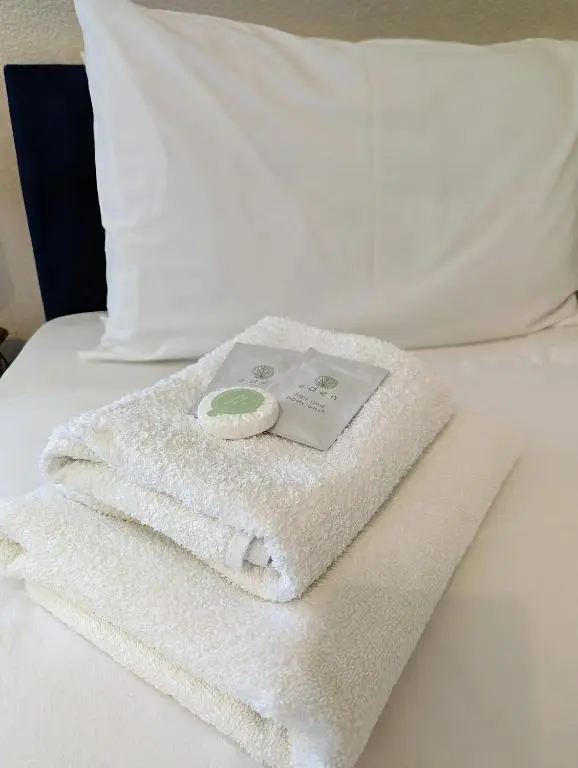 a pile of towels sitting on top of a bed at The Coo's Guest House in Inverness