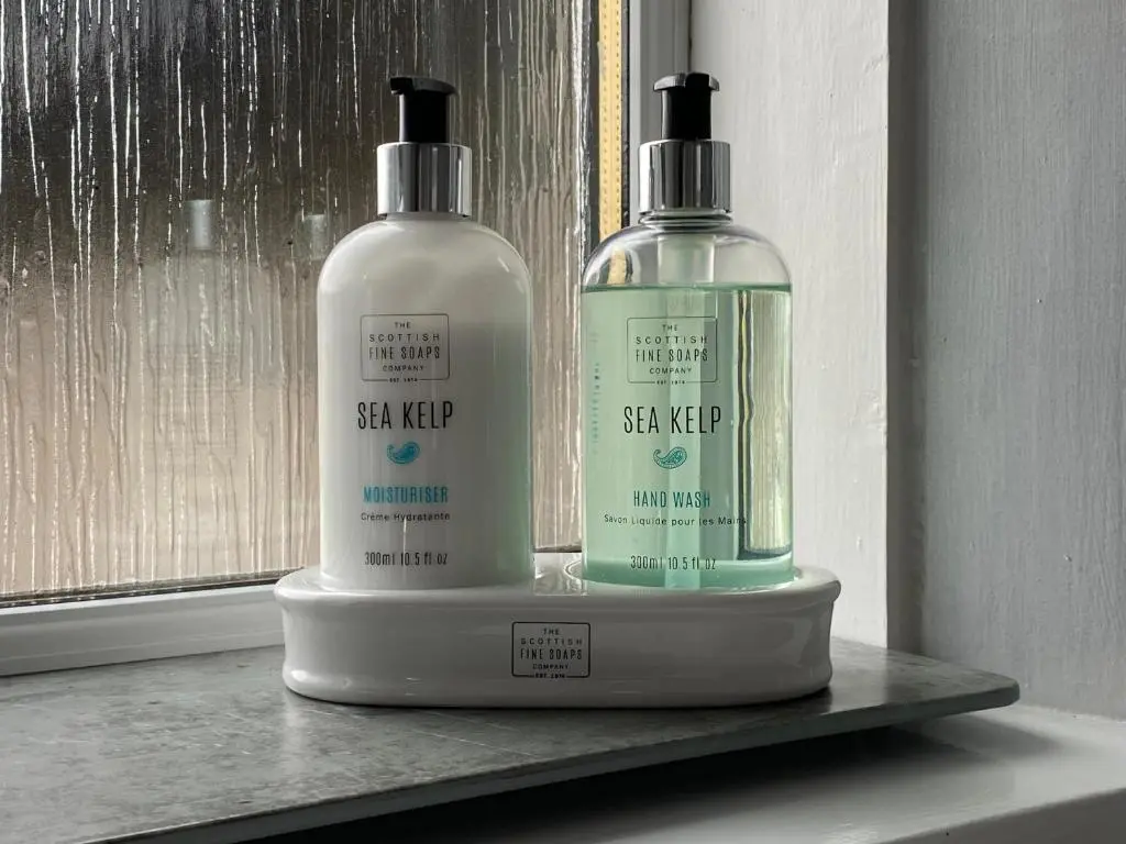 two bottles of soap and shampoo sitting on a shelf at Clune House B&B in Newtonmore