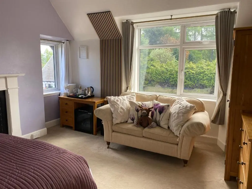 a living room with a couch and a window at Clune House B&B in Newtonmore