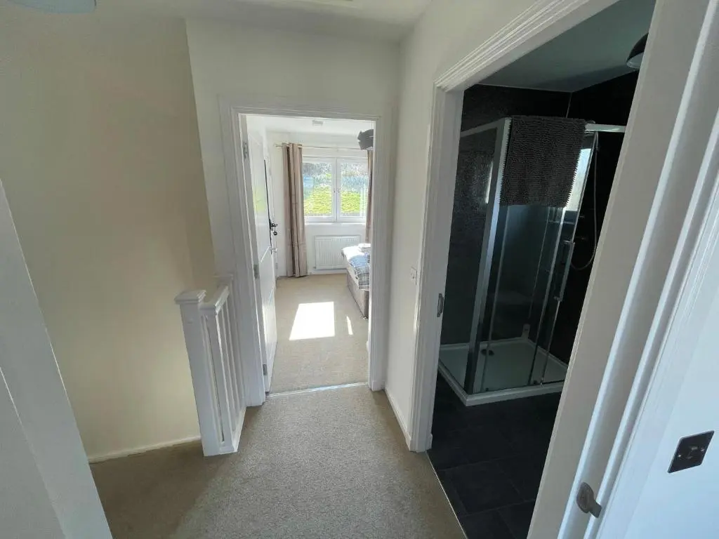 a hallway with a glass door leading to a bathroom at Gorsebank View in Inverness