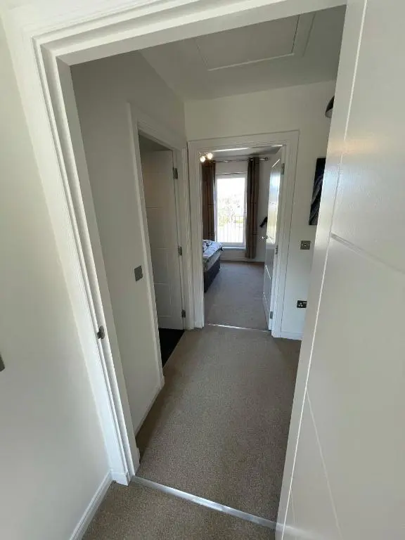 a hallway with white walls and a room with a door at Gorsebank View in Inverness