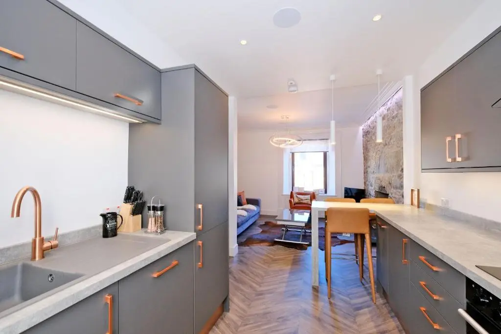 a kitchen with gray cabinets and a dining room at Ben Shea Smart Home in Dufftown