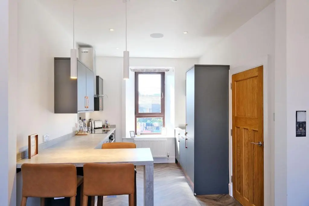 a kitchen with a table and chairs in a room at Ben Shea Smart Home in Dufftown