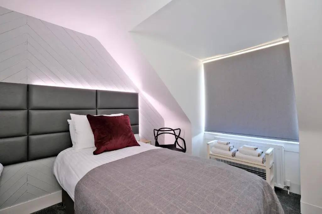 a bedroom with a large bed with a red pillow at Ben Shea Smart Home in Dufftown