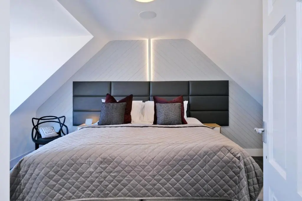 a bedroom with a large bed with a large headboard at Ben Shea Smart Home in Dufftown
