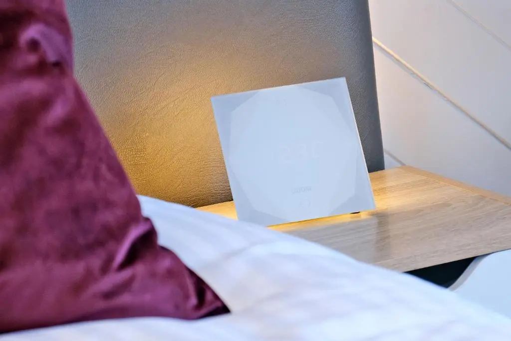 a white sign on a night stand next to a bed at Ben Shea Smart Home in Dufftown