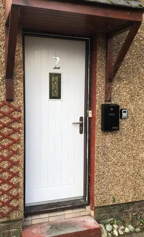 a white door of a house with a mailbox at L&H APARTMENTS in Inverness