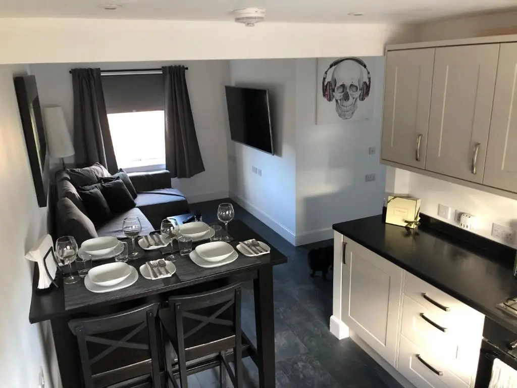 a living room with a table with a skull on the wall at L&H APARTMENTS in Inverness