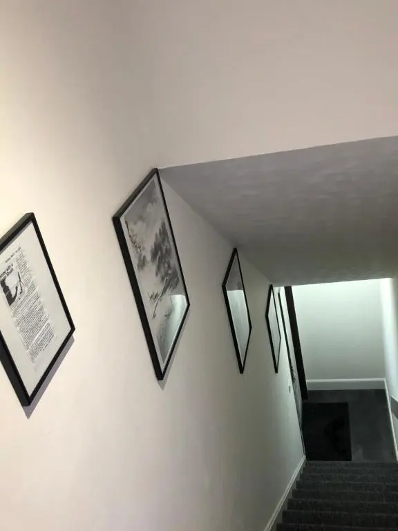 a staircase with three framed pictures on the wall at L&H APARTMENTS in Inverness