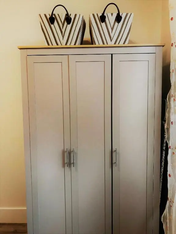 a white cabinet with three umbrellas on top at The King Street Holiday Apartment in Inverness City Centre in Inverness