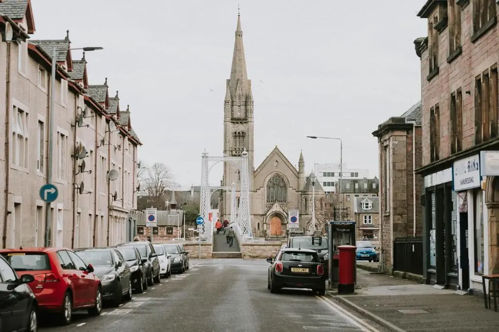 a city street with cars parked in front of a church at The King Street Holiday Apartment in Inverness City Centre in Inverness