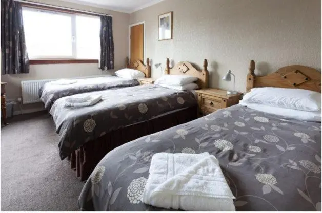 a hotel room with two beds and a window at Queens hotel in Wick