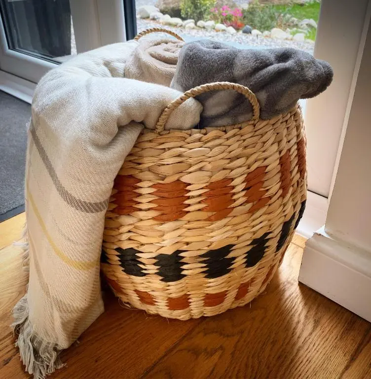 a basket sitting on a floor with a blanket at Druid House Lodge in Inverness