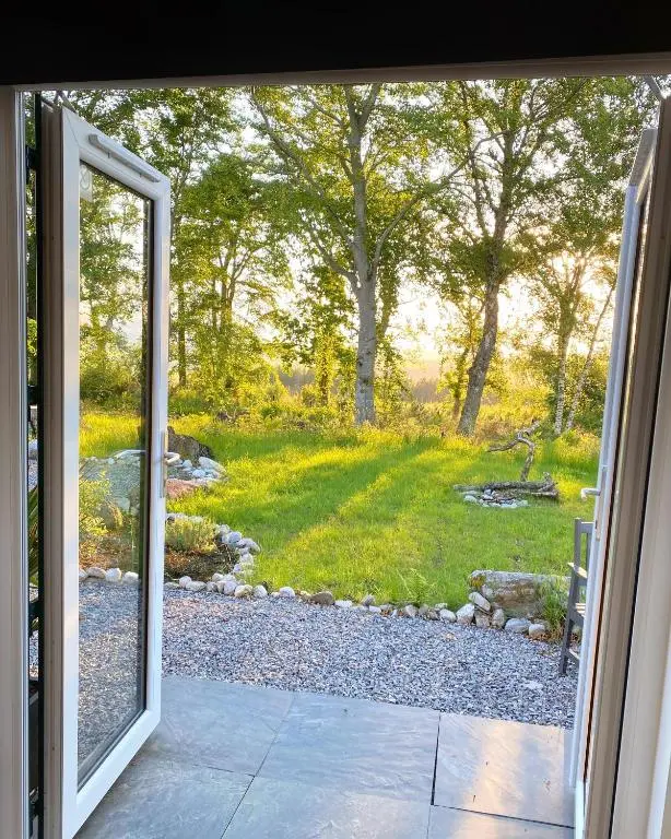 an open door with a view of a yard at Druid House Lodge in Inverness