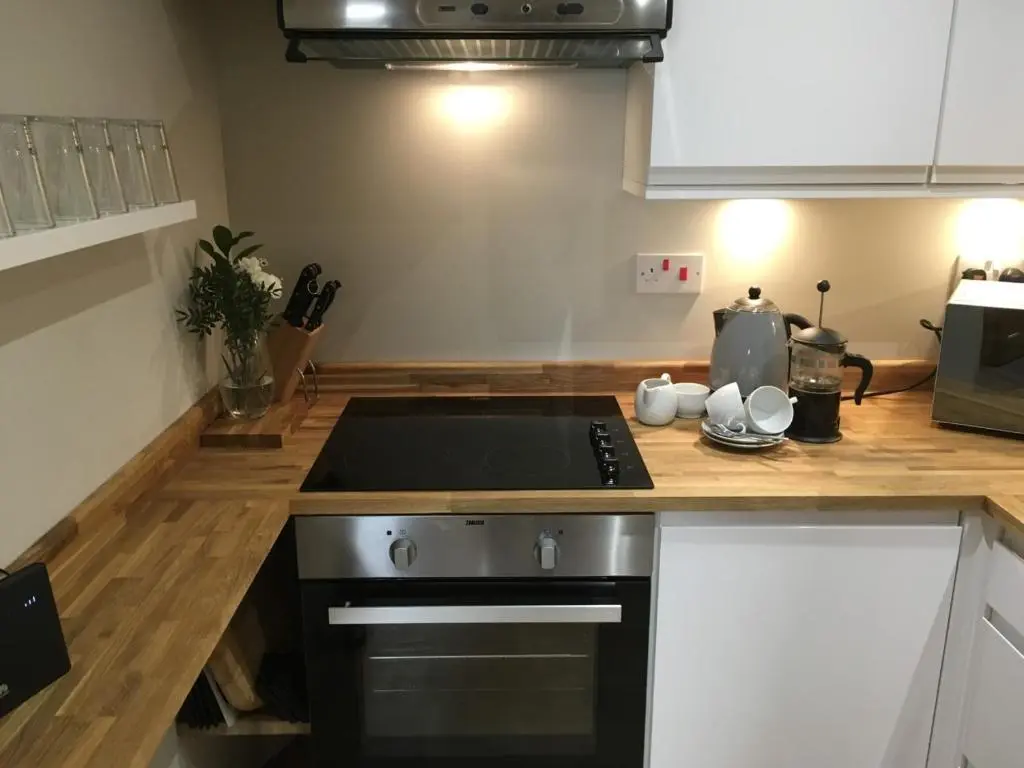 a kitchen with a sink and a stove top oven at Corran Cottage in Inverness