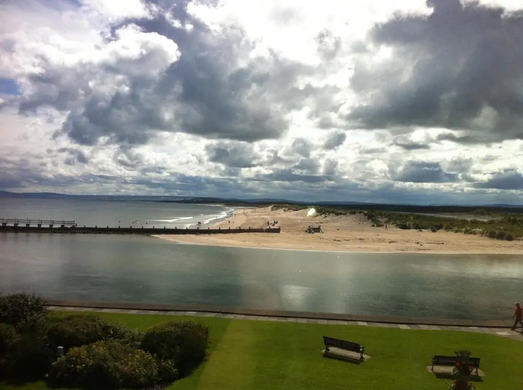 a view of a beach with a pier and a bench at The Jewel of the Moray Firth in Lossiemouth