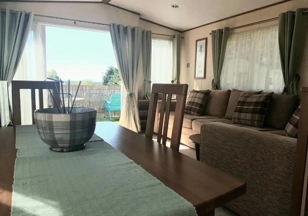 a living room with a table and a couch at No42 Wild Goose in Dornoch
