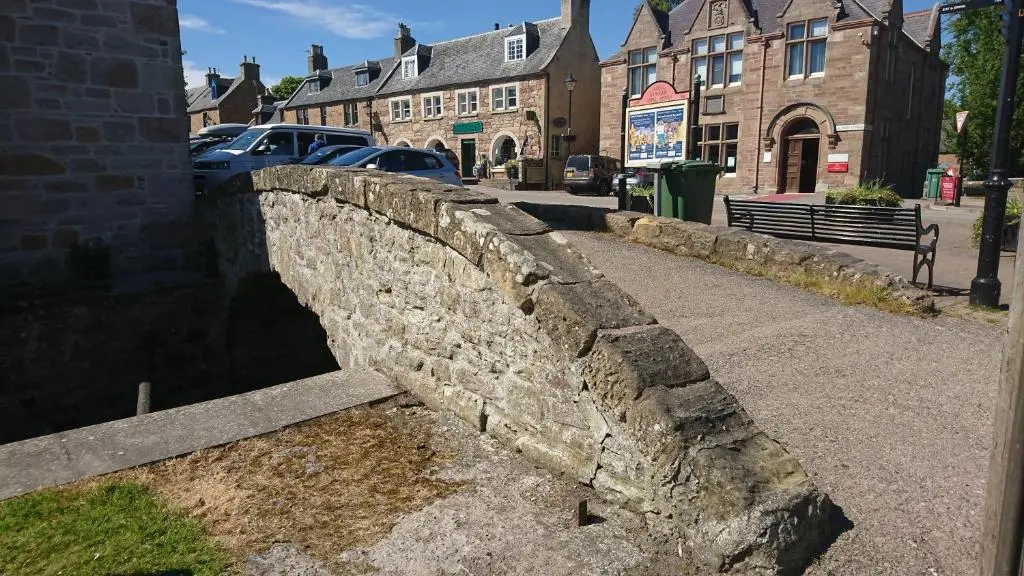 an old stone bridge in a town with buildings at No42 Wild Goose in Dornoch