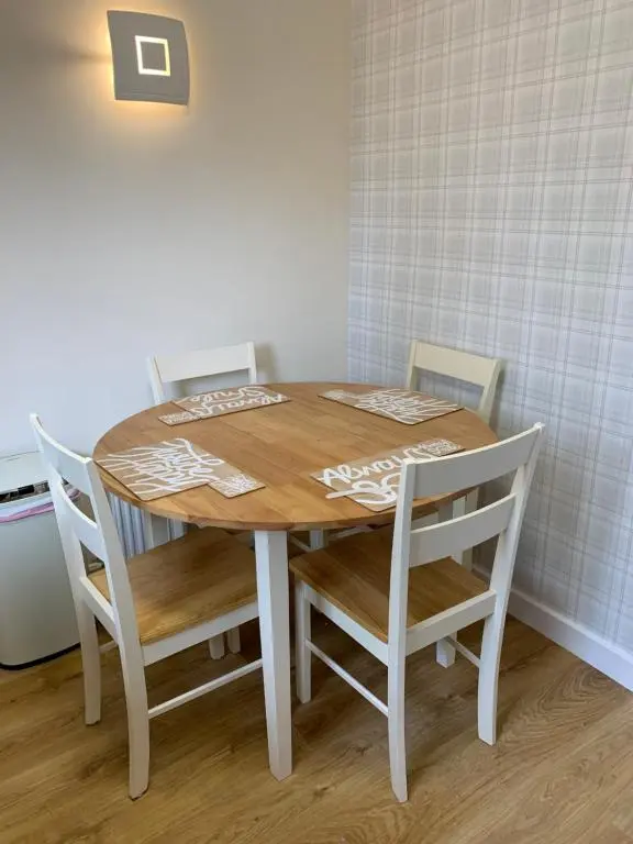 a dining room table with two chairs and a table and a table and chairsktop at Greenfield Cottage in Thrumster