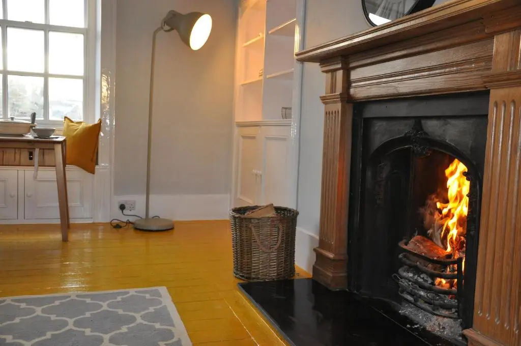 a fireplace in a living room with fire in it at Emahroo Cullen in Cullen