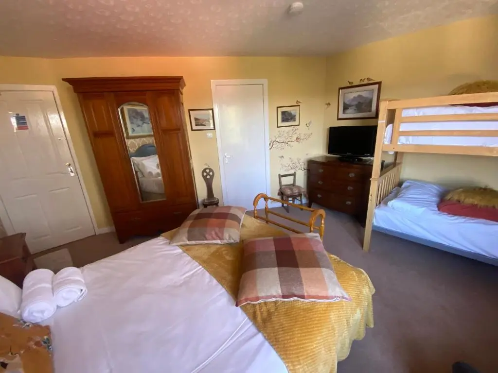 a bedroom with two bunk beds and a television at Bosta B&B in Inverness