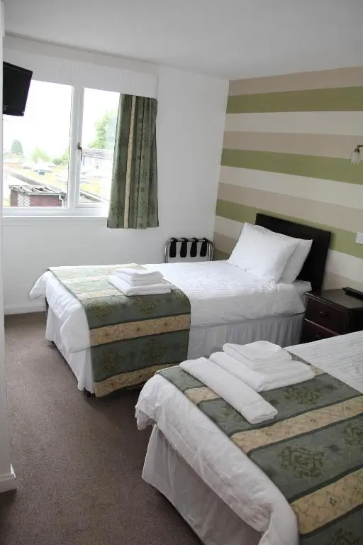 a hotel room with two beds and a window at Ravenswood Social Club in Banchory