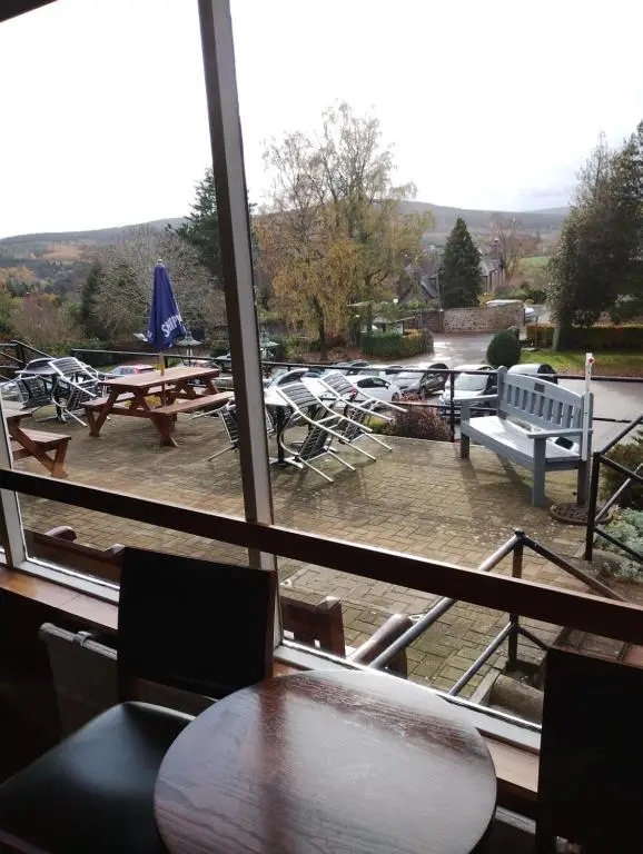 a view from a window of a table and benches at Ravenswood Social Club in Banchory