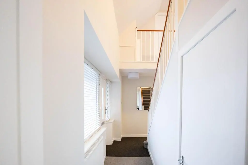 a hallway with white walls and a large window at New Inn Hotel in Ellon