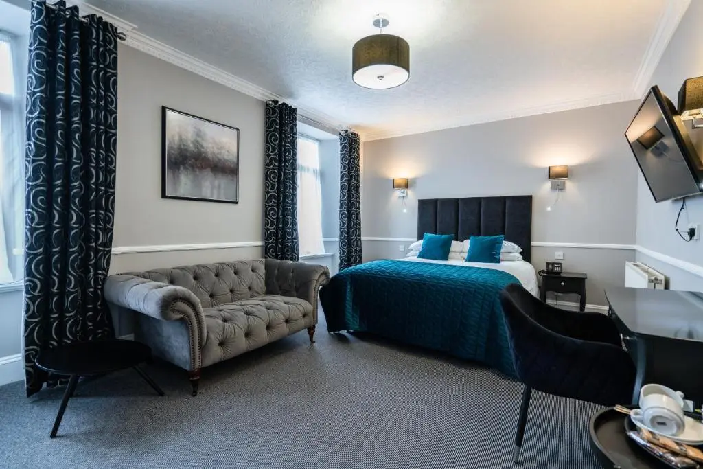 a hotel room with a bed and a couch at New Inn Hotel in Ellon