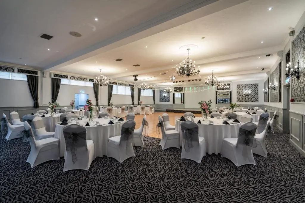 a banquet hall with white tables and chairs at New Inn Hotel in Ellon