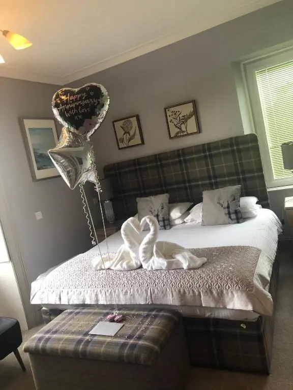 a bedroom with a bed with two hearts and balloons at Redcliffe Hotel in Inverness