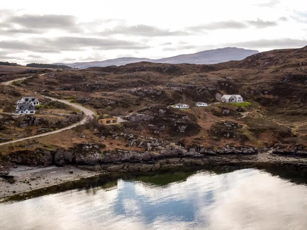an aerial view of a hill with houses and a body of water at Tigh na Mara in Ullapool