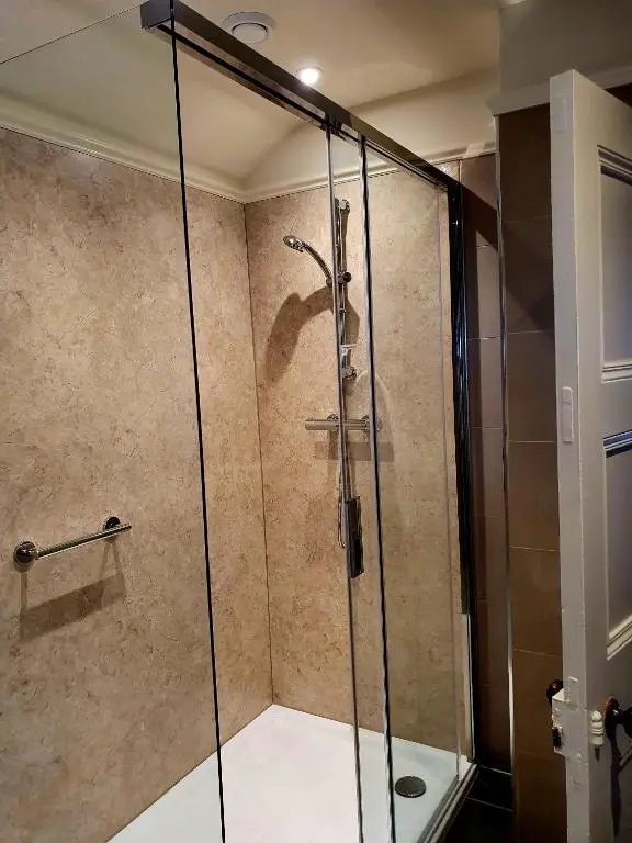 a shower with a glass door in a bathroom at The Redgarth in Oldmeldrum