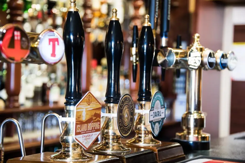 a group of bottles of beer on a bar at The Redgarth in Oldmeldrum