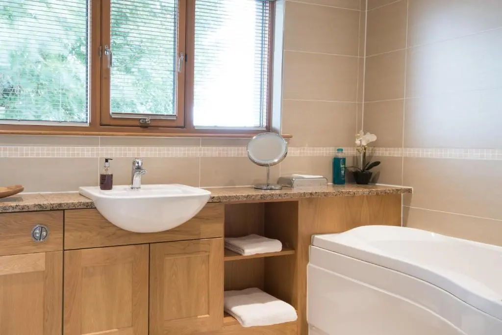 a bathroom with a sink and a toilet and a mirror at The Redgarth in Oldmeldrum