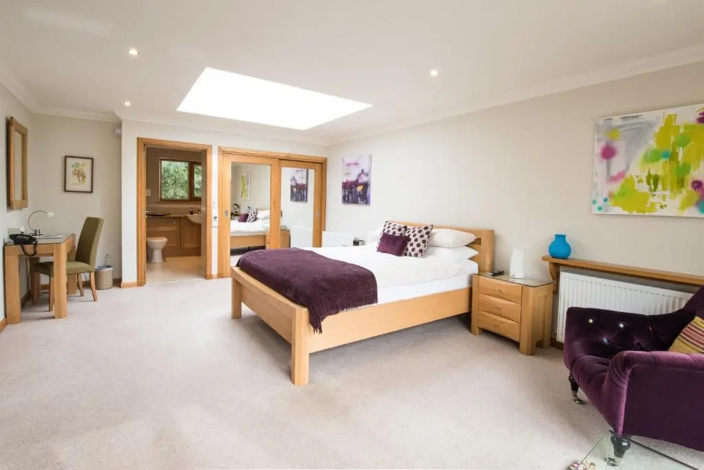 a bedroom with a bed and a couch at The Redgarth in Oldmeldrum