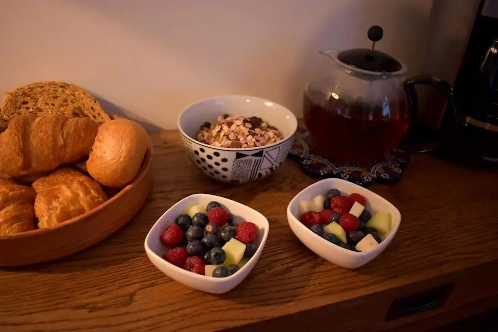 a table with three bowls of fruit and bread at Lycia Rooms + in Inverness