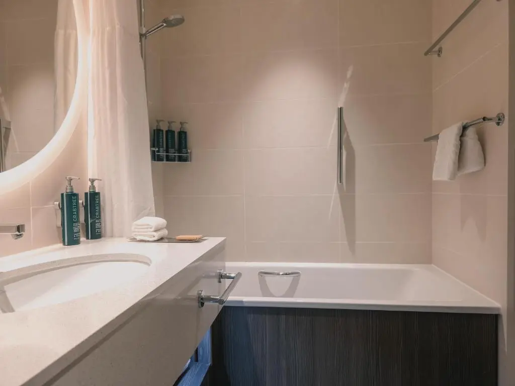 a white bathroom with a tub and a sink at Hilton Aberdeen TECA in Aberdeen