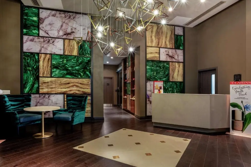 a lobby with a table and a wall of glass at Hilton Aberdeen TECA in Aberdeen