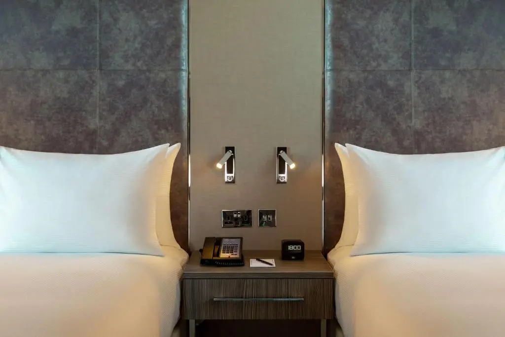 a hotel room with two beds and a phone on a table at Hilton Aberdeen TECA in Aberdeen