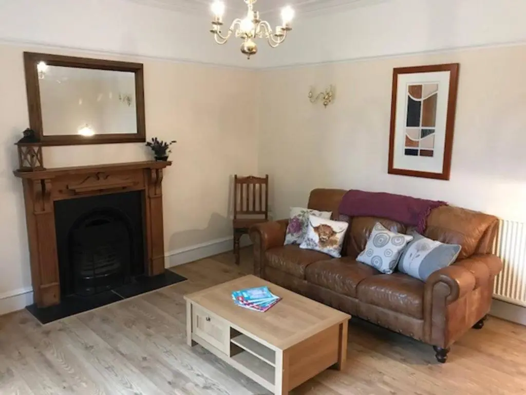 a living room with a couch and a fireplace at Traditional Family Home in Royal Deeside in Aboyne