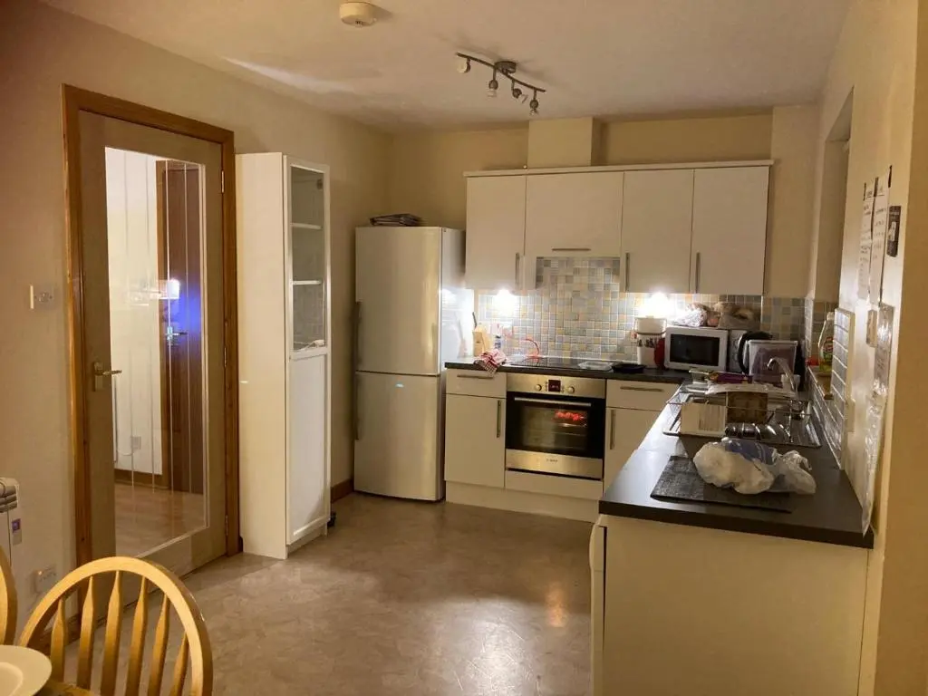 a kitchen with white cabinets and a counter top at Sunbury Aviemore in Aviemore