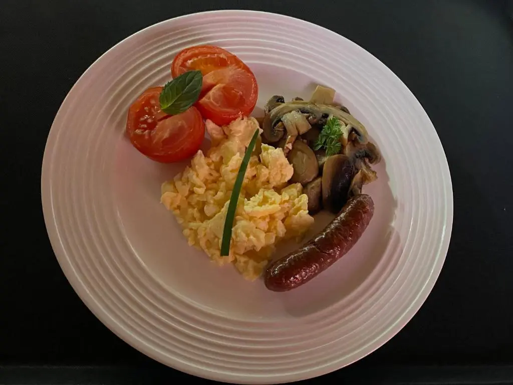 a plate of food with rice and sausage and tomatoes at Garden Park Guest House in Grantown on Spey